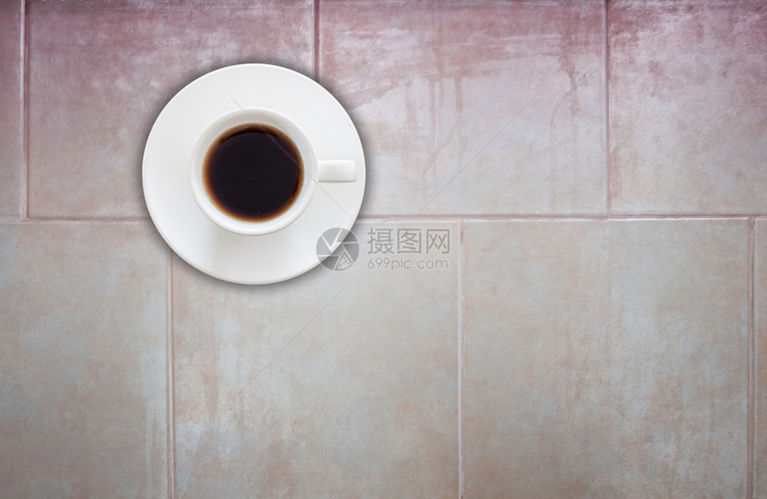 瓷砖墙壁纹理背景上的咖啡杯顶部视图图片