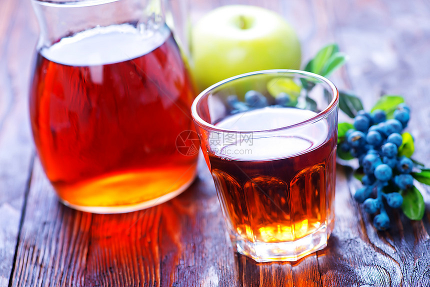 新鲜的果汁在玻璃杯和桌子上图片