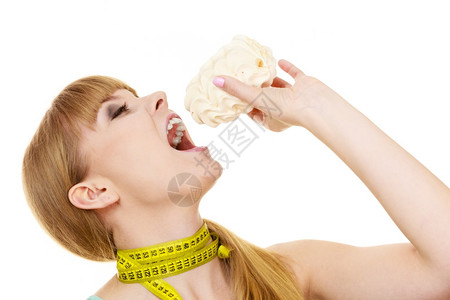 女在脖子上被蓝色的测量胶带压住了手握着蛋糕甜食试图抵制诱惑背景图片