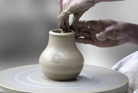 妇女手在陶器和轮盘上制造陶瓷杯图片