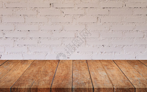 在咖啡店装饰白砖墙的棕色木桌顶图片