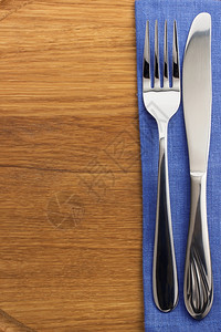 木板上的餐巾刀叉和图片