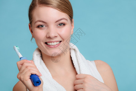 年轻女孩用牙膏刷白年轻女孩用电刷白牙快乐女人用膏清洗口腔关心牙科健康图片
