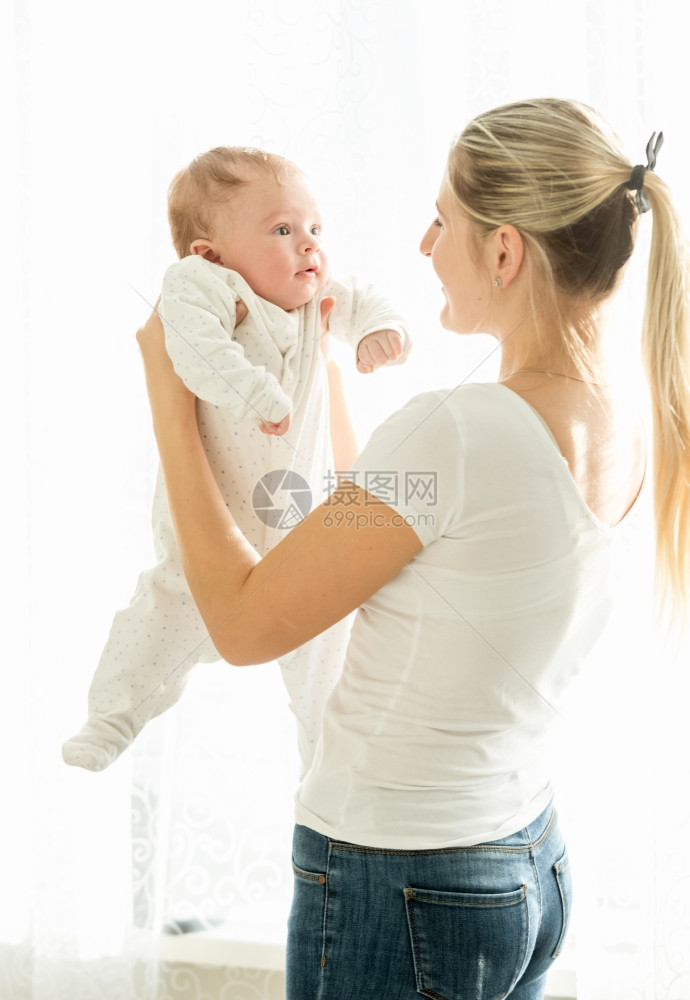 美丽的微笑妈肖像抱着她三个月大的婴儿图片