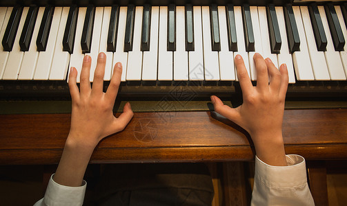 小女孩弹钢琴的近画面高清图片