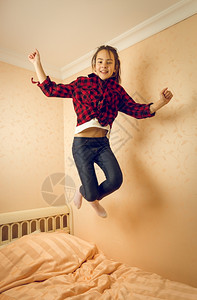 少女在床上跳跃图片