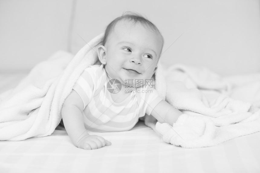 躺在毯子下可爱的男孩黑白画像图片