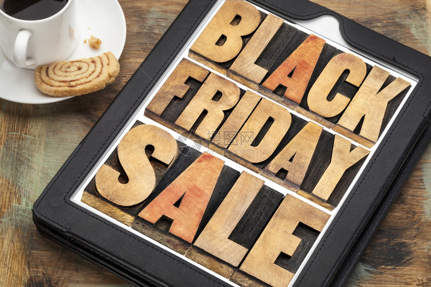 黑色星期五销售假日购物概念在带有咖啡的数码平板上用纸质木型文字摘要图片