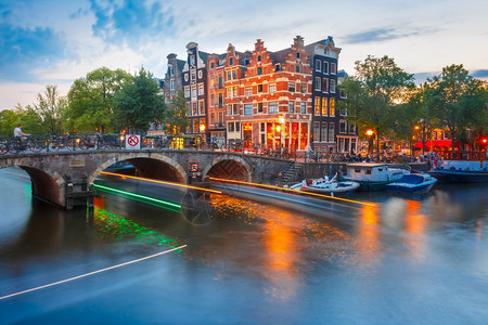 荷兰阿姆斯特丹运河桥梁和典型房屋船只和光亮的轨高清图片