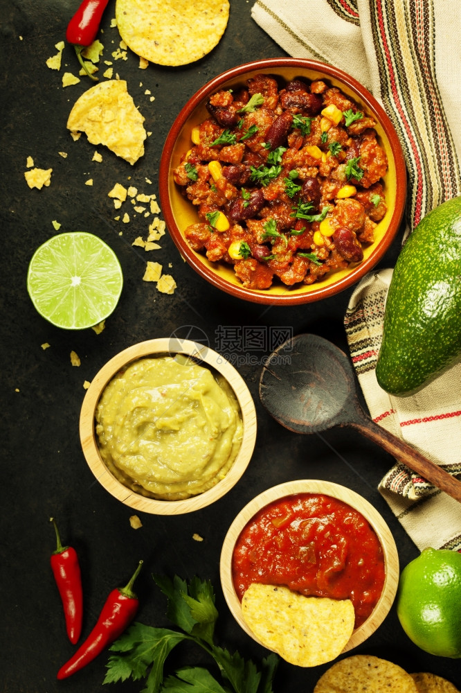 墨西哥食物概念玉米饼薯片瓜卡莫乐萨尔带豆子的辣椒和古老生锈金属背景的新鲜原料图片