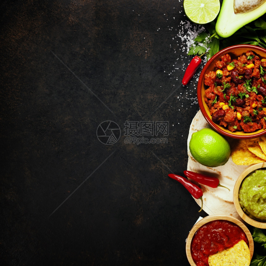墨西哥食物概念玉米饼薯片瓜卡莫乐萨尔带豆子的辣椒和古老生锈金属背景的新鲜原料图片