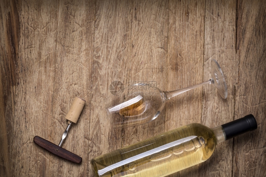 玻璃瓶酒木制餐桌背景上装有软木的瓶酒图片