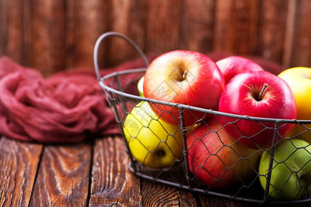 桌子上的苹果金属篮中的红苹果图片