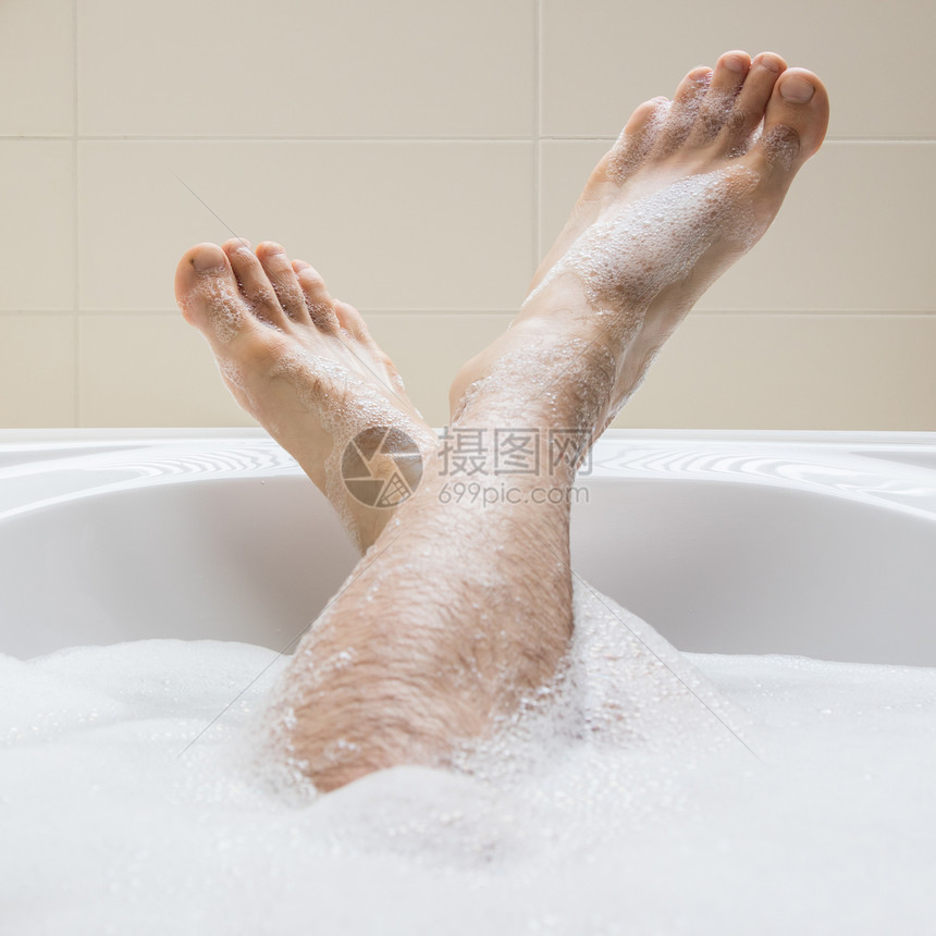 男人脚在明亮的白浴缸里有选择地关注脚趾图片