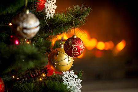 红色和金的面包树在烧火壁炉背景上挂在圣诞树图片