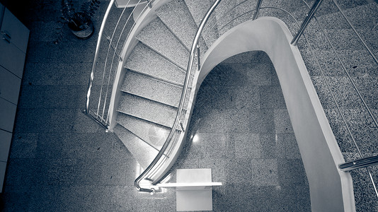 现代建筑中石块弯曲楼梯的单色图像背景图片