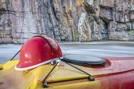 白水汽艇头盔在一条对立面的码头上快速的河流和悬崖背景图片
