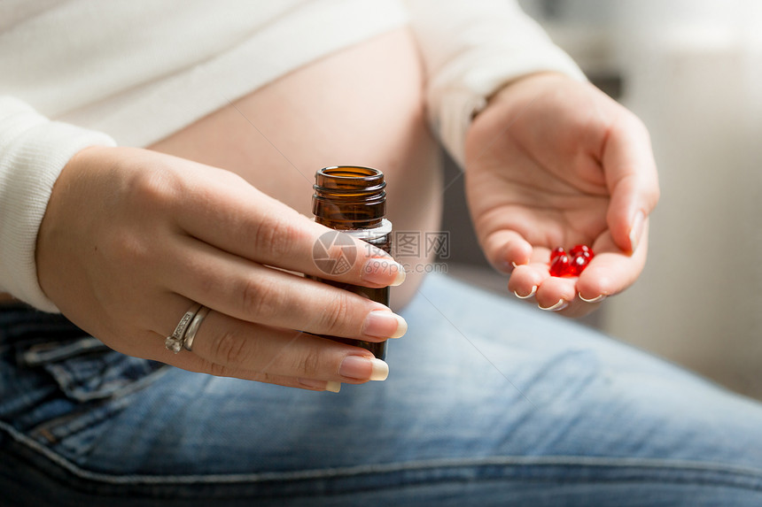 孕妇手持红色药片图片