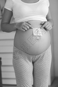 孕妇的黑色和白图像腹部贴有后乳纸上的问号生活高清图片素材