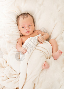 新生婴儿男孩躺在毯子下床上婴儿室高清图片素材