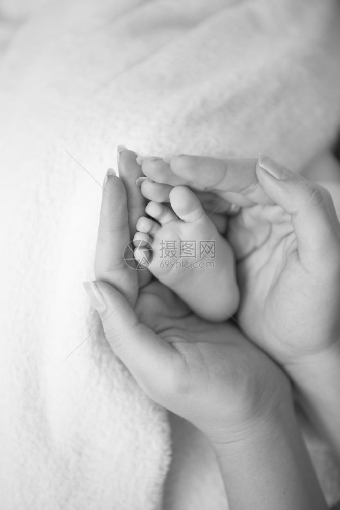 母亲手中新生婴儿脚的照片图片
