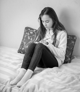 少女在卧室日记中作笔的黑白画像图片