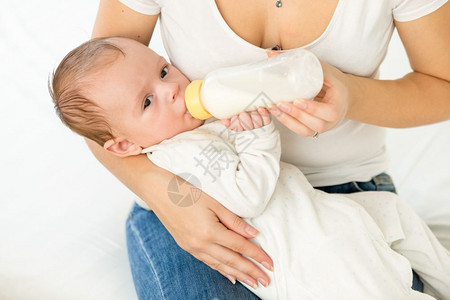 母亲给婴儿喂牛奶的肖像图片