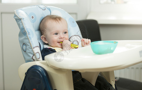 婴儿男孩坐在高椅子上厨房和吃饭的椅子上图片