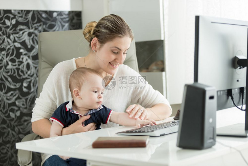 妇女教婴儿如何使用计算机的肖像图片