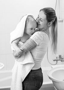 洗澡后拥抱母亲的可爱小男孩黑白画像小孩高清图片素材