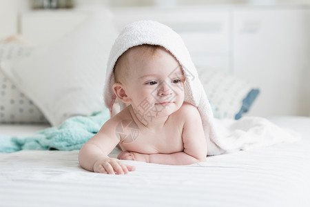 洗澡后在毛巾下照看9个月的婴儿快乐图片