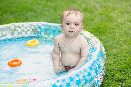 小对月草坐在充气游泳池里的九个月大小孩背景