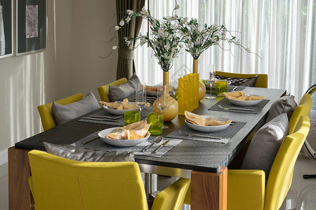 暖黄色餐厅餐桌和舒适的黄色椅在现代家庭使用优雅的桌椅背景