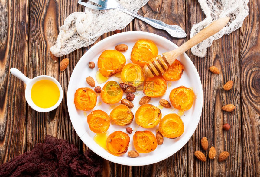 餐桌上加蜂蜜和坚果的烤杏子图片