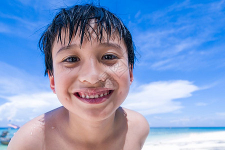 一个男孩在海滩上微笑令人愉快的高清图片素材