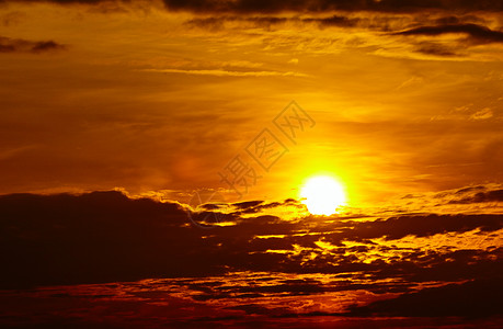 日落时有云的彩色天空金背景图片