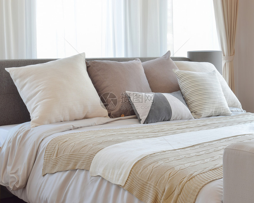时髦的卧室内设计床上有棕色的枕头和装饰桌灯图片