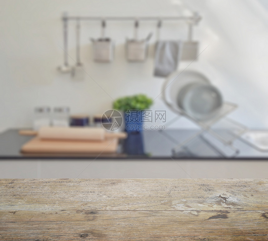 顶有现代陶瓷厨房用具和柜台模糊的木制桌顶图片