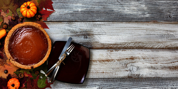 秋天食物南瓜新鲜烘烤自制南瓜派和感恩节甜点餐盘背景