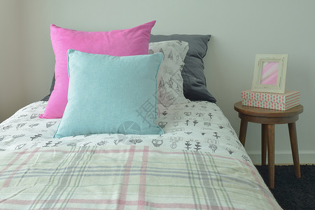 床上的枕头和床边桌子的相框蓝色高清图片素材