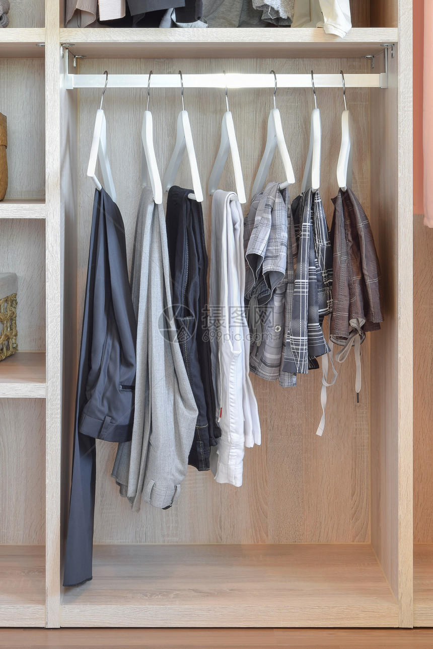 现代衣柜有一排裤子挂在木制衣柜内图片