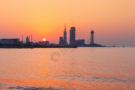 格鲁吉亚日出日落时现代巴统佐治亚阿贾拉从海滩到现代城市景色在美丽的日落时由Skyscrapersferris轮和字母塔观看格鲁吉亚巴统Adj背景