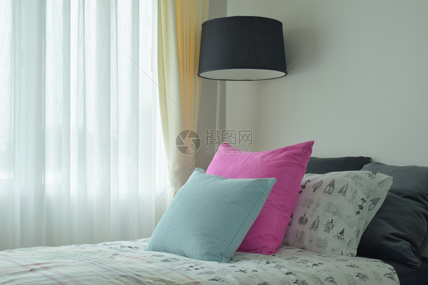 单人床上的浅蓝色和粉红枕头图片