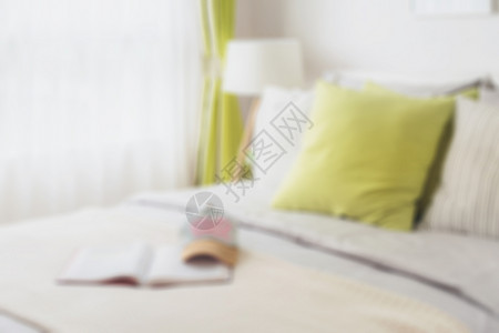 现代卧室的模糊床边绿色枕头为背景背景图片