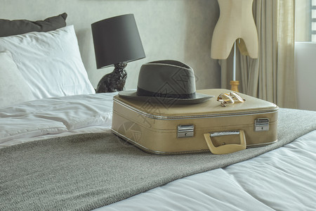 旅馆客房的床上行袋帽子和墨镜图片