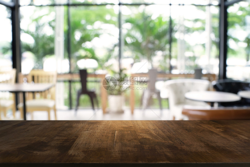 在餐厅的抽象模糊布基背景面前的空黑木桌可以用于显示或调制您的产品图片