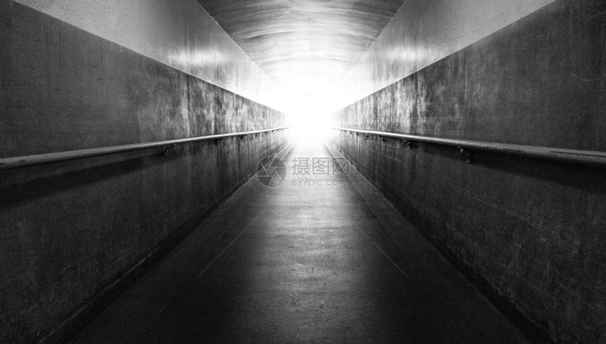 一条长的地下走廊通往表和隧道尽头的光线图片