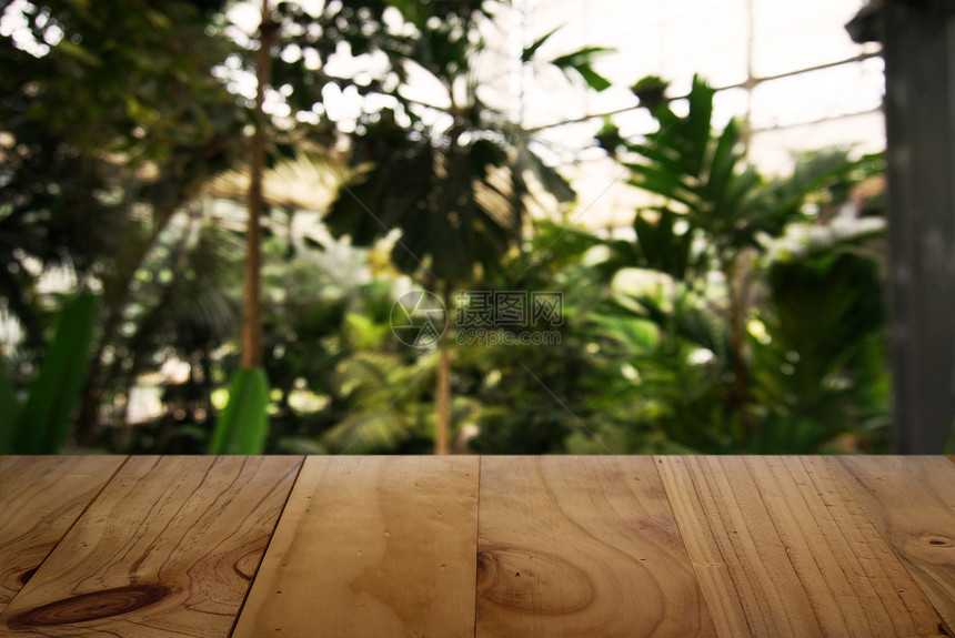咖啡店的抽象模糊背景面前的空木板可以用来显示产品模版图片