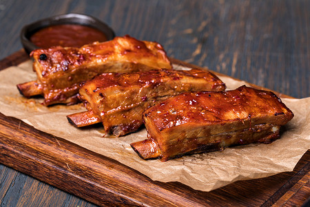 烤猪排木板上烧烤酱中的猪排背景图片