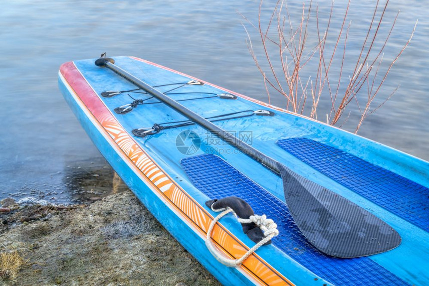赛车在湖岸上拿着桨站在板上图片